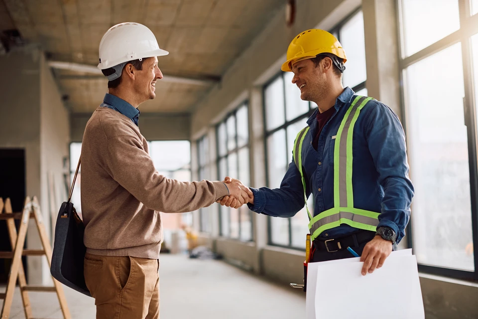Carpenter rencontre le client en studio, serrer la main et parler de l'assemblage de meubles commandés